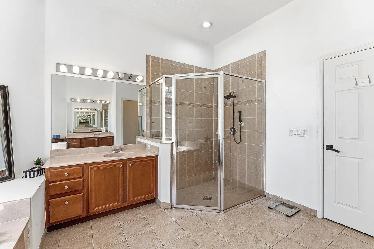 Full bathroom with a glass-enclosed walk-in shower and wood vanity