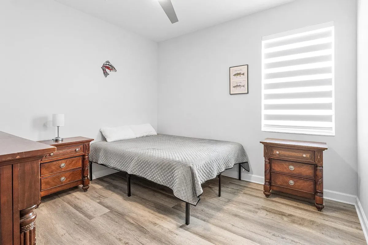 Bedroom with ceiling fan and a window to the side yard