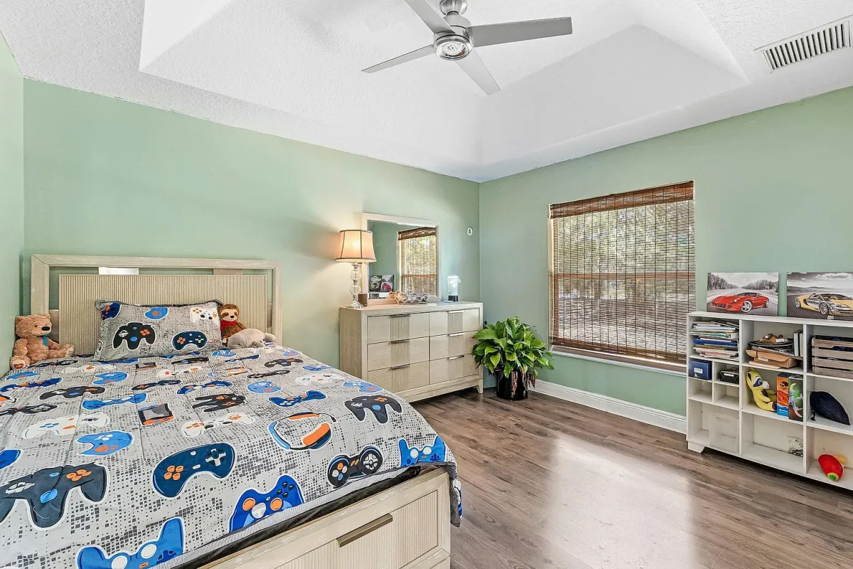 Bedroom with painted accent wall and window to the yard
