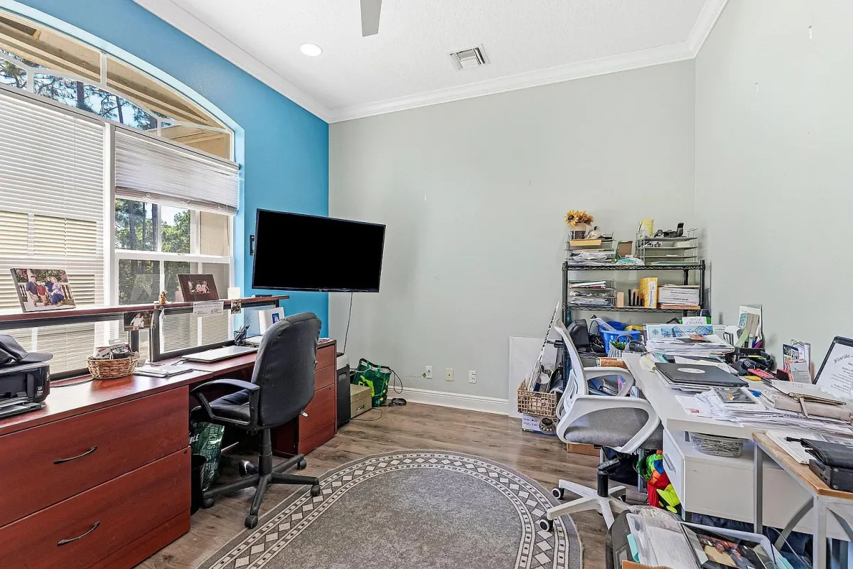 Den set up as a home office, with a built-in desk run and window to the front yard