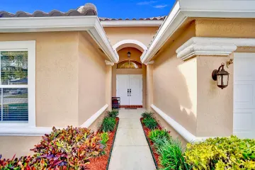 Covered walkway leading to the home’s white double front doors