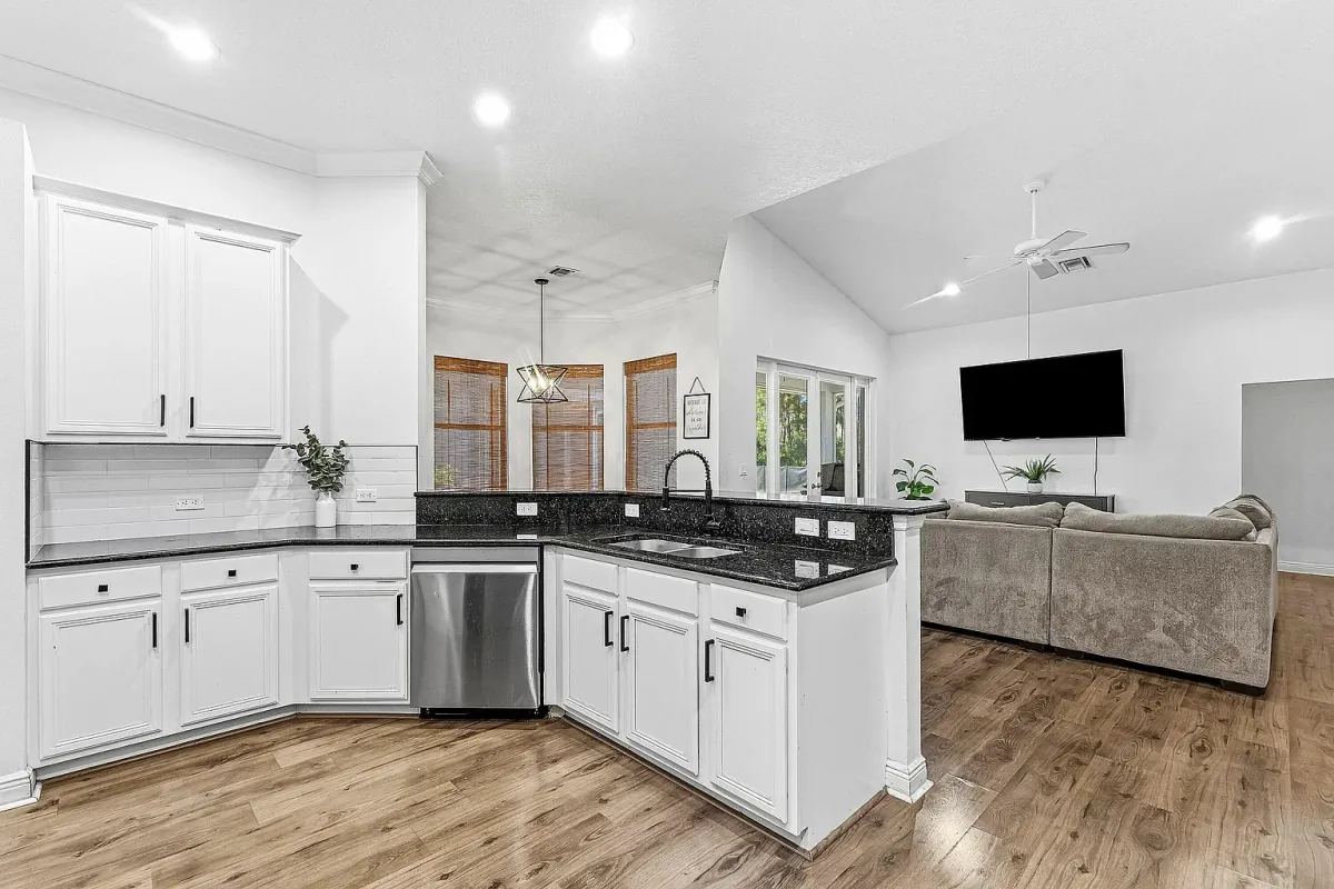Kitchen open to the living area, with breakfast bar and wall-mounted TV