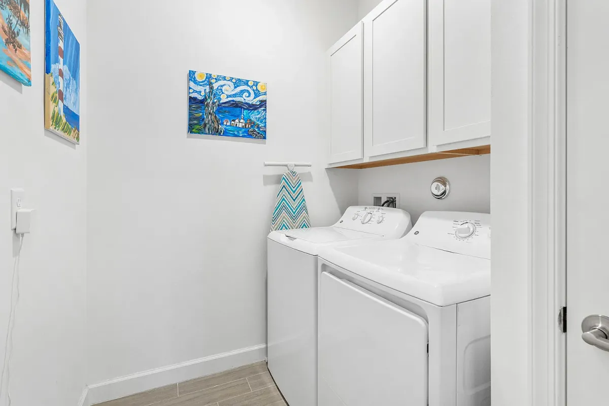 Interior laundry room with washer, dryer and overhead cabinets