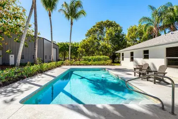Saltwater pool and paved deck, with the metal workshop beyond