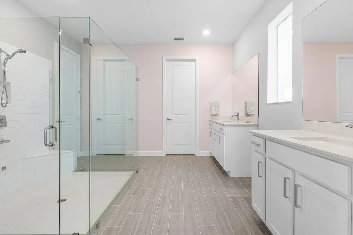 Primary bathroom with dual-sink vanity and glass-enclosed walk-in shower