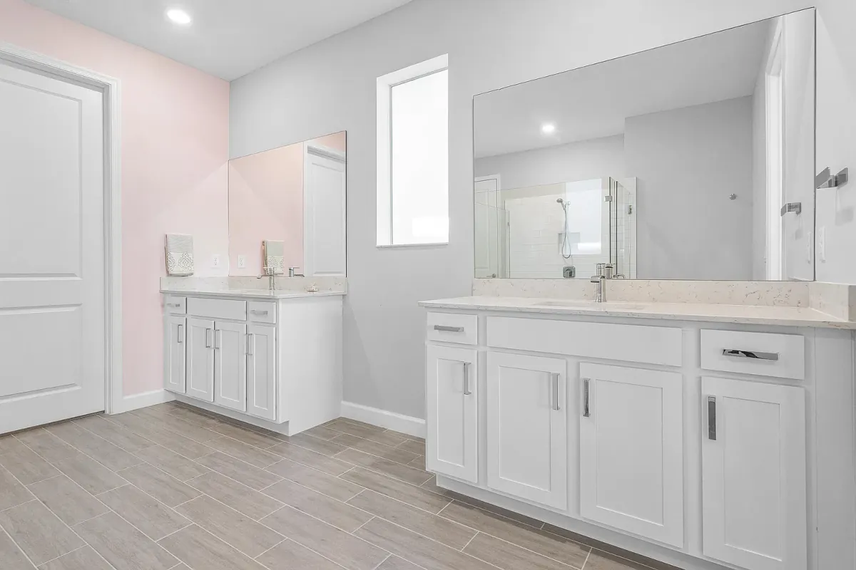 Primary bathroom dual-sink vanity with wide mirror